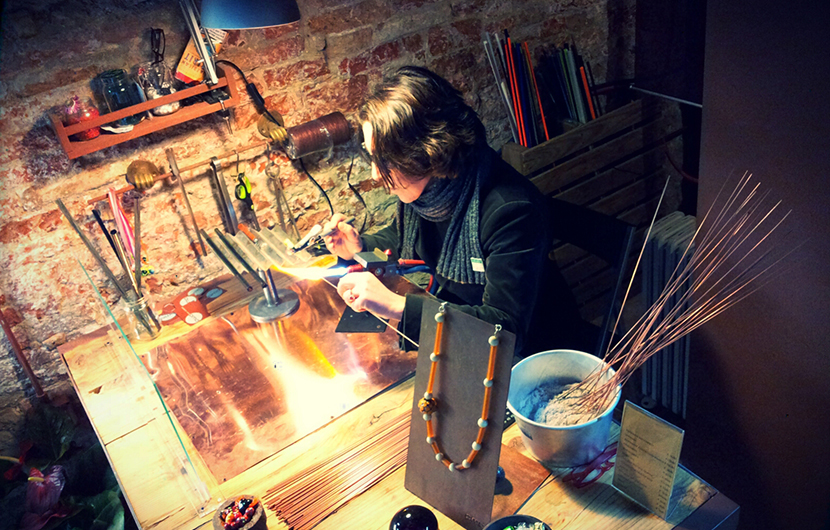 Artesã da Perlamadredesign fazendo pecinhas de murano para uma jóia, em Veneza